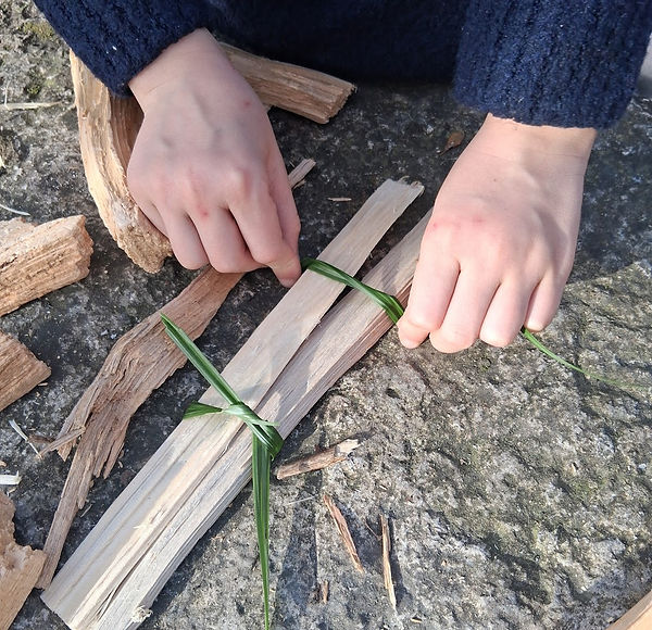 Child building a wooden boat from natural materials